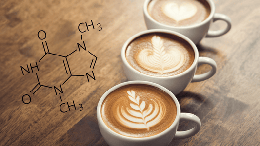 Drei Tassen Kaffee stehen auf dem Tisch, daneben steht die chemische Formel von Koffein.